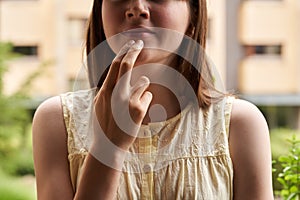 Teenager practicing EFT or emotional freedom technique - tapping on the chin point photo