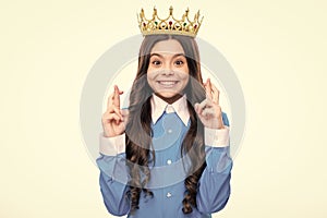 Teenager princess child celebrates success win and victory. Teen girl in queen crown isolated on white background.