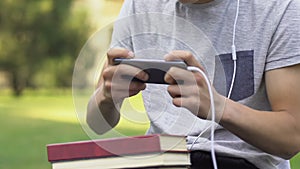 Teenager put aside books with homework to play video game, addiction concept