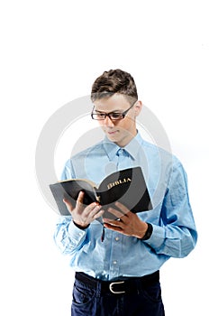 Teenager read and study from big book bible with eyeglasses isolated on white background