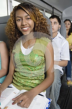 Teenager Reading Textbook In School Bus