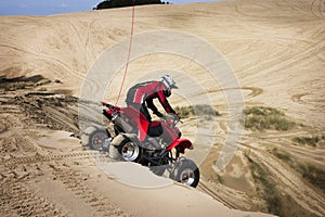 Teenager Riding ATV in Sand Dunes
