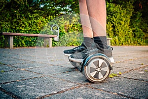 Teenager riding a hoverboard at schoolyard - self-balancing scooter, levitating board used for personal transportation