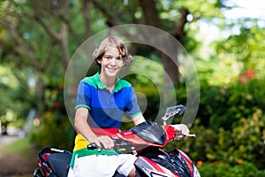 Teenager riding scooter. Boy on motorcycle.