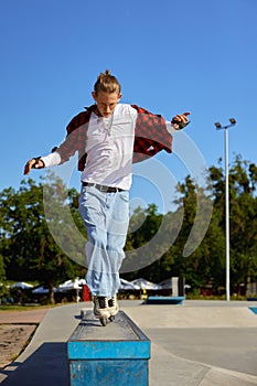 Teenager rollerskater balancing on pedestal performing extremely ride tricks