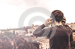 Teenager on the roof of the house in the headphones