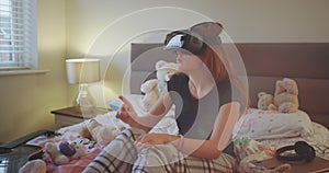 On a teenager room girl laying on the bed and using a new technology VR to play a virtual game , she are very