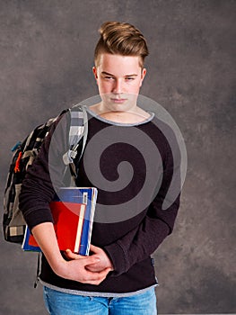 Teenager with satchel and books looking angry