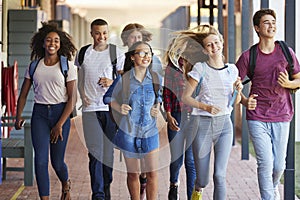 Teenager school kids running in high school hallway photo