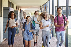 Teenager school kids running in high school hallway