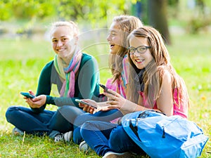 Teenager schoolgirls having fun with mobile phones