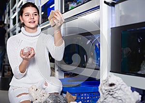 Teenager selecting interesting aquarium rocks and stone for aqua