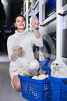 teenager selecting interesting aquarium rocks and stone for aquarium entourage