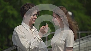 A teenager shares headphones with a girl