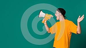 Teenager shouting using megaphone over turquoise background