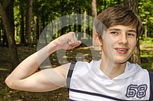Teenager shows biceps on his hands