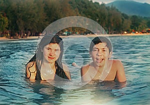 Teenager siblings couple brother and sister swimming in the sea