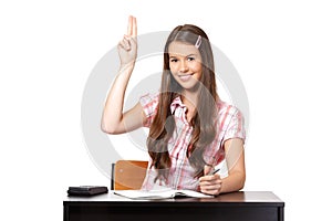 Teenager sitting in classroom with raisedhand
