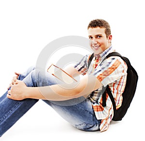 Teenager sitting on floor with book and rucksack