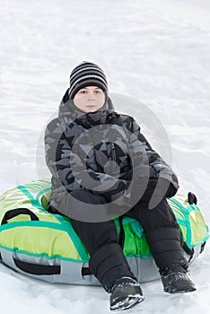 Teenager sitting on green tubing