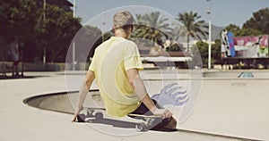 Teenager is Sitting on His Longboard