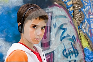 Teenager sitting near a graffiti wall