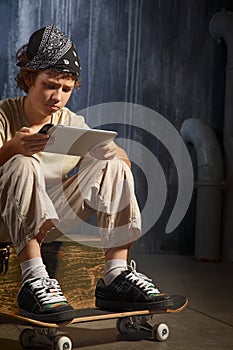 Teenager sitting on skateboard