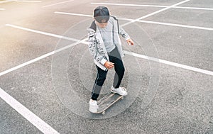 Teenager skateboarder boy with a skateboard on asphalt playground doing tricks. Youth generation Freetime spending concept image