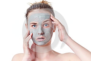 Teenager skincare concept. Young teen girl with dried clay facial mask making funny face