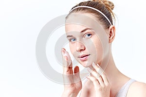 Teenager skincare. Smiling beautiful teen girl with freckles and blue eyes using foaming cleanser. Face washing concept