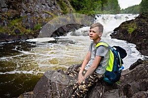 Teenager standing near the mountain waterfall
