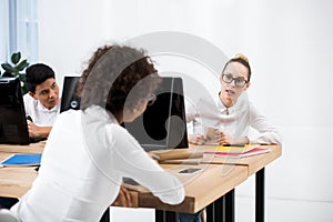 teenager student girls sitting at table and looking