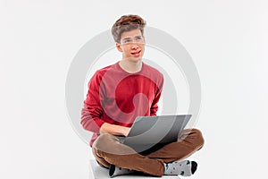 Teenager student thinking and working at laptop on white backgro