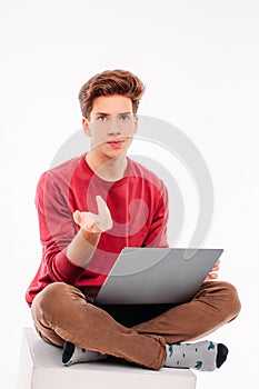 Teenager student working at laptop on white background