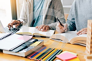 Teenager studying at desk and doing homeworks and using laptop.