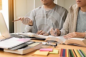 Teenager studying at desk and doing homeworks and using laptop