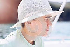 Teenager in a sunscreen straw hat during a sunny day.