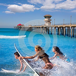 Teenager surfers running jumping on surfboards