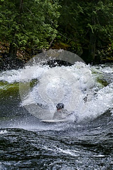 Teenager surfing the Pipeline wave on the Lochsa River, Idaho
