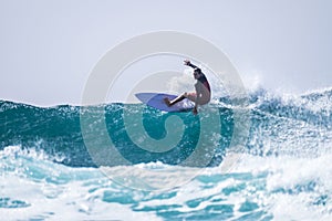 Teenager surfing at the wave in tenerife playa de las americas - red wetsuits and beautiful and perfect wave photo