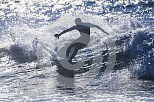 Teenager surfing at the wave in tenerife playa de las americas - white wetsuits and beautiful and perfect wave