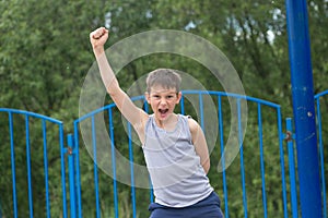 A teenager in a T-shirt and shorts celebrates the victory