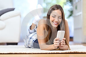 Teenager texting on the mobile phone in the living room