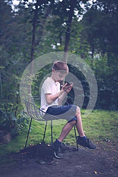 Teenager texting mobile phone messages row on nature background. Vertical frame