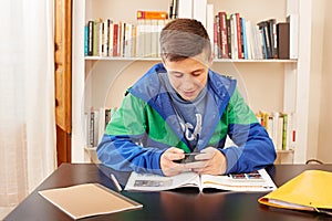 Teenager texting with smartphone while studying