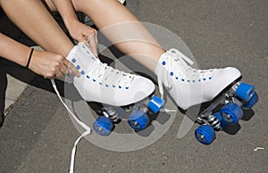 Teenager tying laces on a pair of roller skates