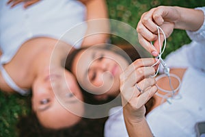 A teenager untangling headphones wire