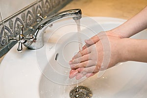 Washing hands in the bathroom sink. Frequent hand washing is a prerequisite for good hygiene in the face of the photo