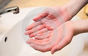 Washing hands in the bathroom sink. Frequent hand washing is a prerequisite for good hygiene in the face of the photo