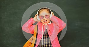 Teenager younf school girl with wearing eyeglasses backpack and headphones.